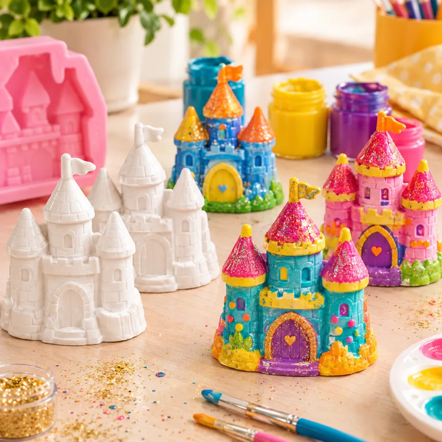 Castelinhos de gesso brancos prontos para pintar, ao lado das mesmas peças pintadas por crianças